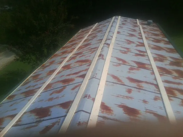 Rusted metal roof panels with new wood purlins before replacement — Storm Damage Roof Repair in Croton by Roofing Brothers