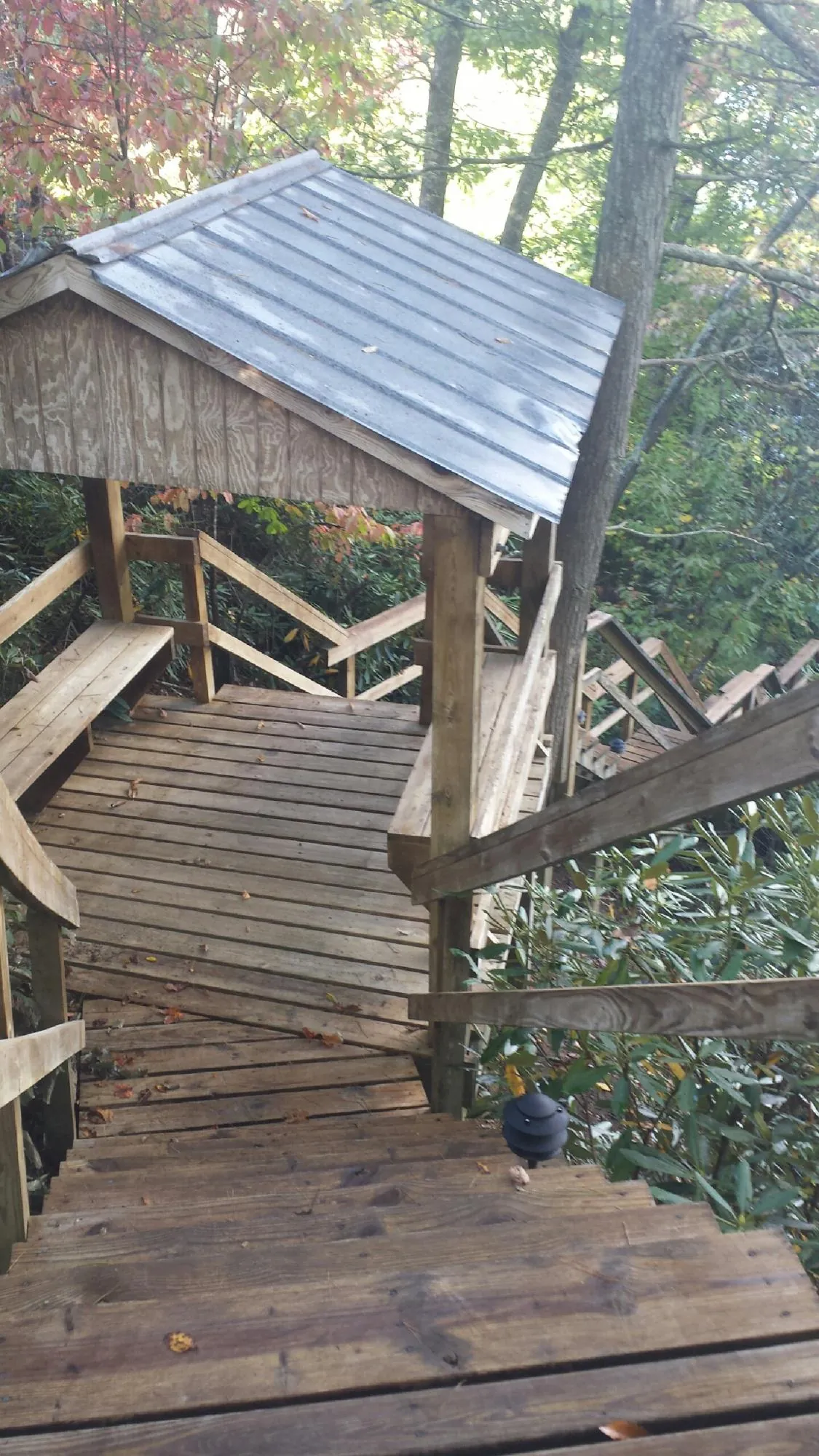 Metal roofed shelter over wooden steps on a wooded walkway — Skylight Repair & Installation work by our crew in Croton