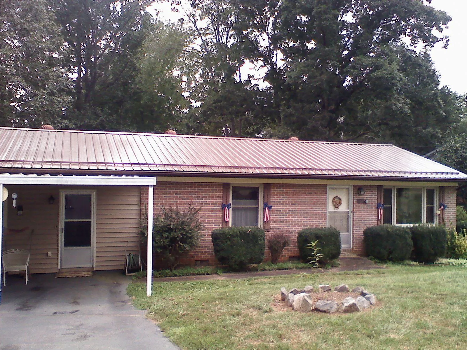 Bronze metal roof and carport on a brick ranch home — Roof Repair work by our crew in Croton
